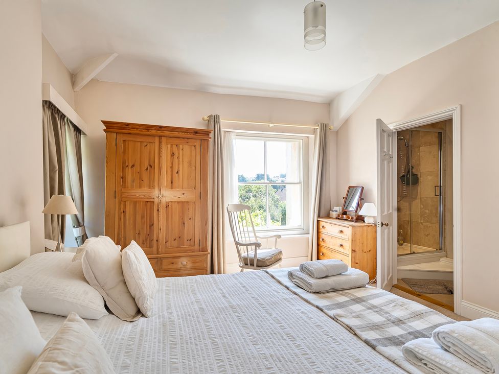 A bedroom with a bed and wardrobe at East Wing in Crewkerne