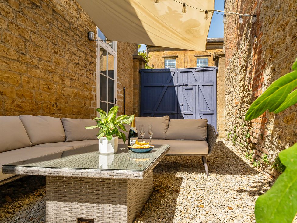 An outdoor patio with a couch and table at East Wing in Crewkerne