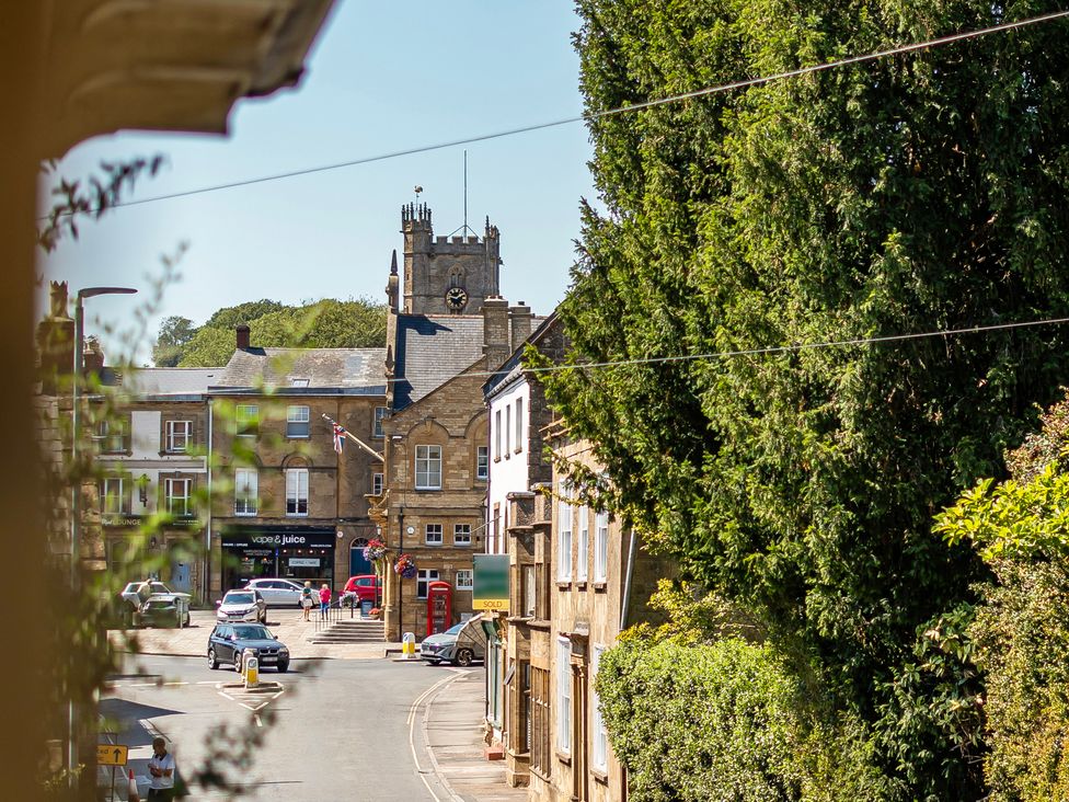 A view of a clock tower and street scene at East Wing in Crewkerne