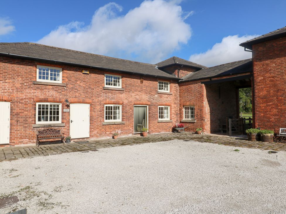 An outdoor view of a brick building with windows and a gravel driveway at The Dairy Eastwood