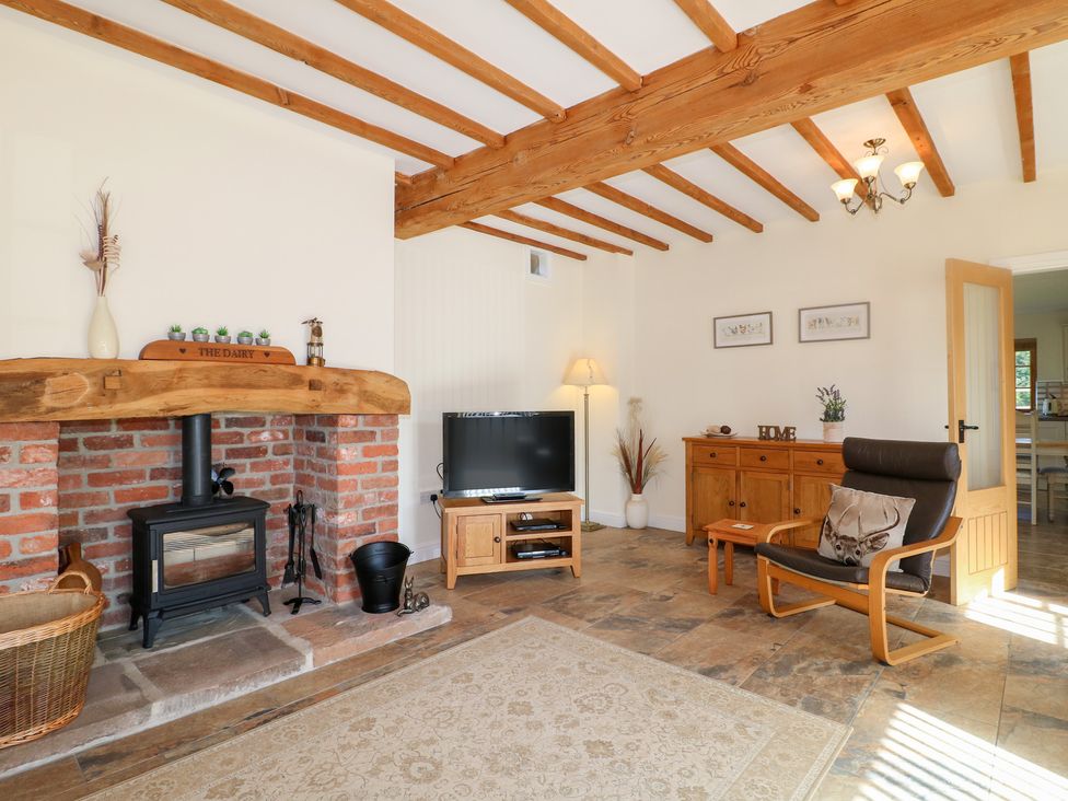A living room with a fireplace and television at The Dairy in Eastwood