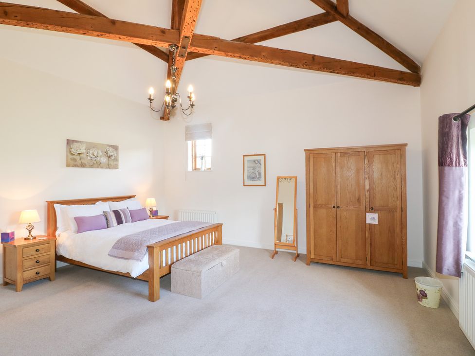 A bedroom with a bed and wardrobe at The Dairy in Eastwood