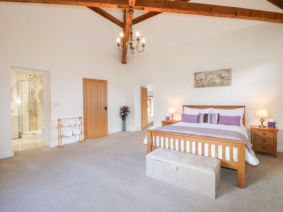 A bedroom with a bed and two bedside tables at The Dairy in Eastwood