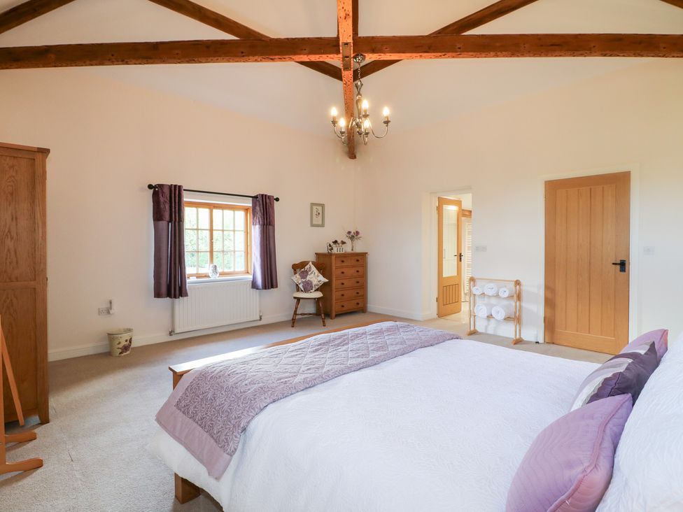 A bedroom with a bed and chest of drawers at The Dairy in Eastwood