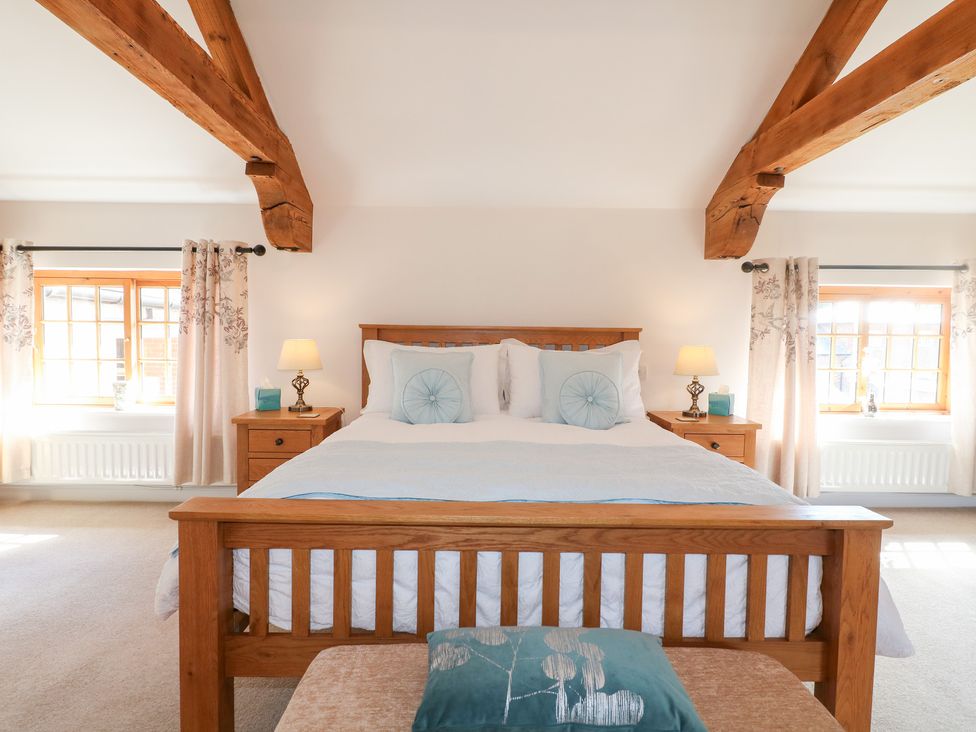 A bedroom with a bed and bedside tables at The Dairy in Eastwood