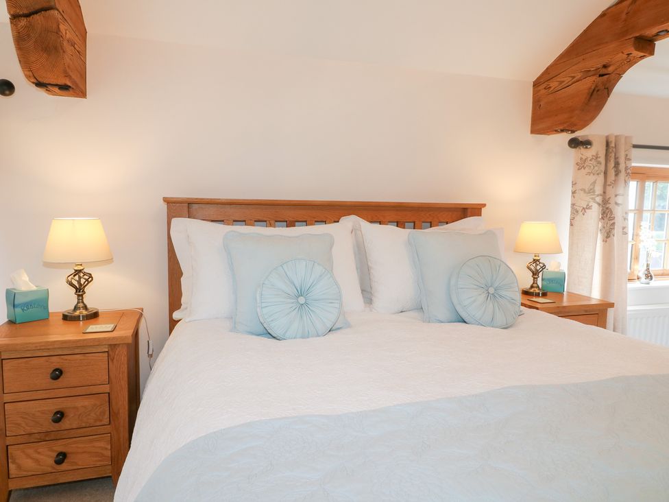 A bedroom with a bed and nightstand at The Dairy in Eastwood