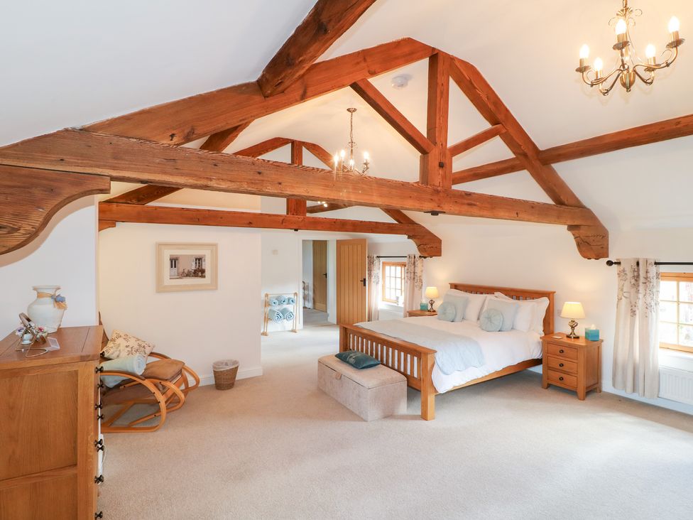 A bedroom with a bed and nightstand at The Dairy in Eastwood