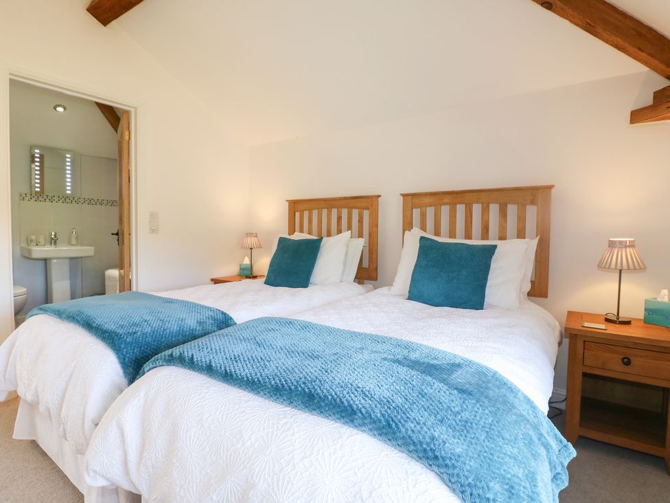 A bedroom with twin beds and adjoining bathroom at The Dairy Eastwood