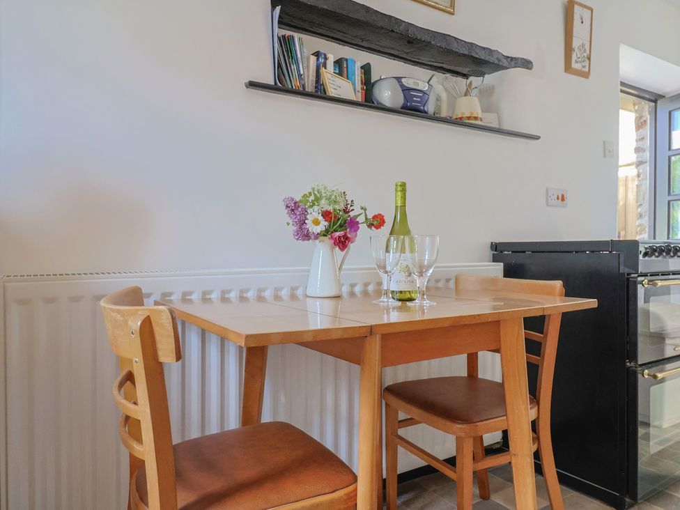 A dining room with a table and chairs at The Old Workshop in Knowstone