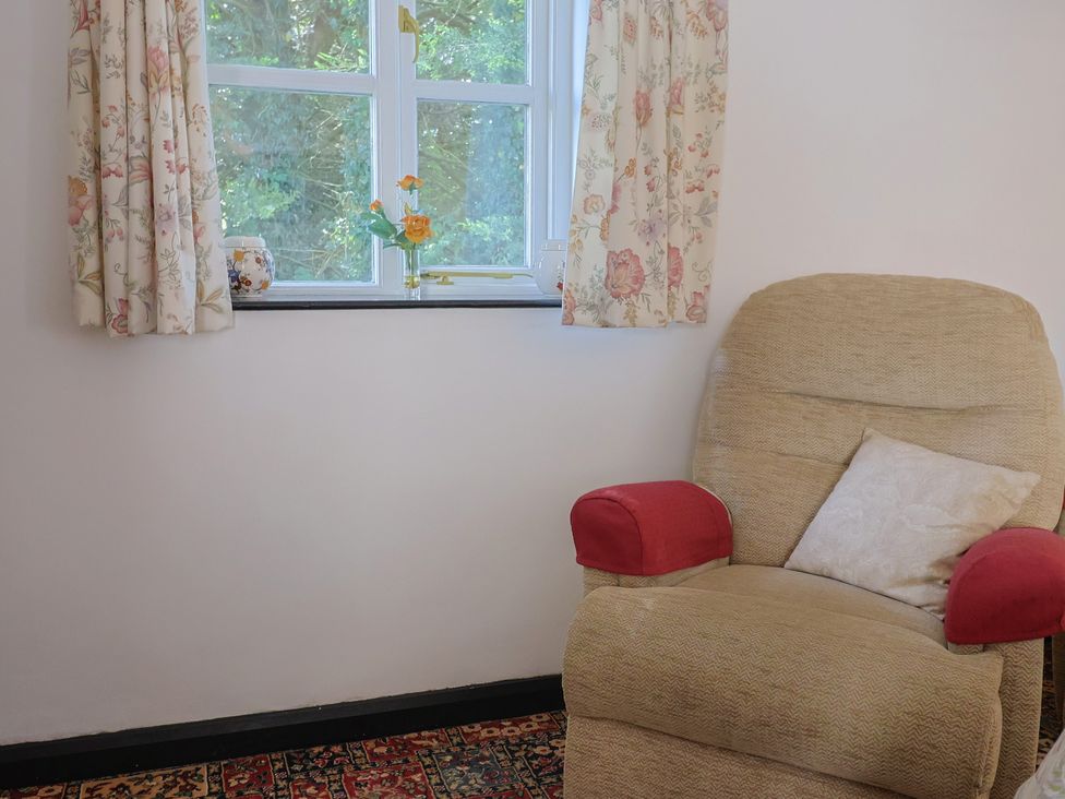 A sitting room with a recliner chair and a window at The Old Workshop in Knowstone