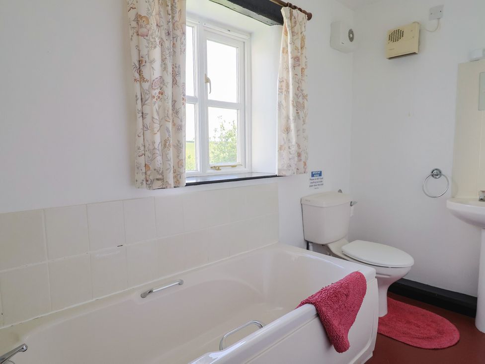A bathroom with a bathtub and toilet at The Old Workshop in Knowstone