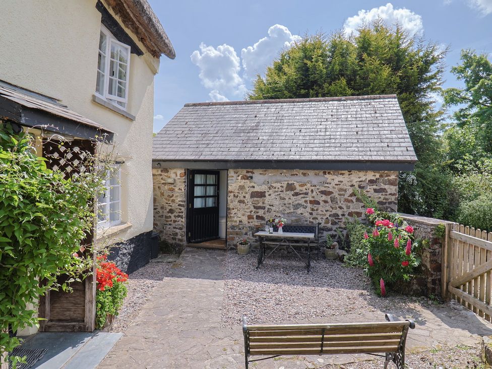 An outdoor area with a bench and table at The Old Workshop in Knowstone