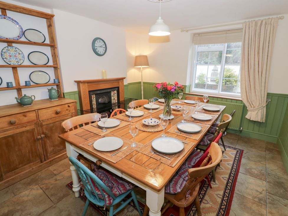 A dining room with a large wooden table set for dinner at Town Mill in Bewdley