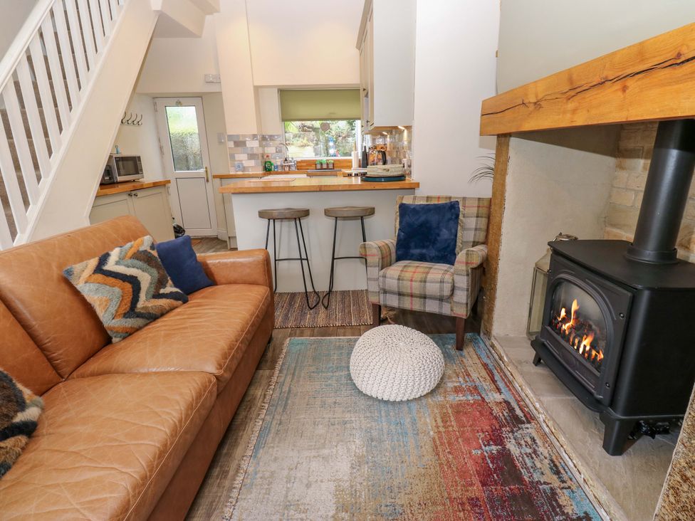 A living room with a sofa and fireplace at Maria Cottage in Haworth
