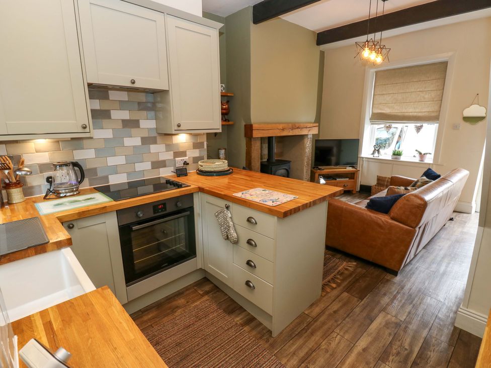 A kitchen with an oven and a couch at Maria Cottage in Haworth