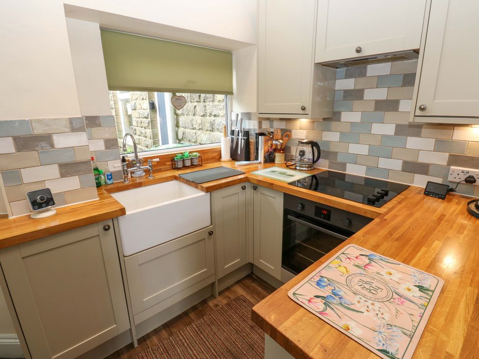 A kitchen with a sink and stove at Maria Cottage in Haworth