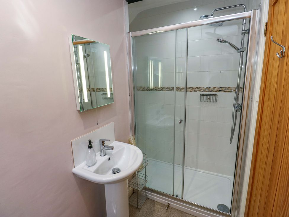 A bathroom with a sink and shower at Maria Cottage, Haworth