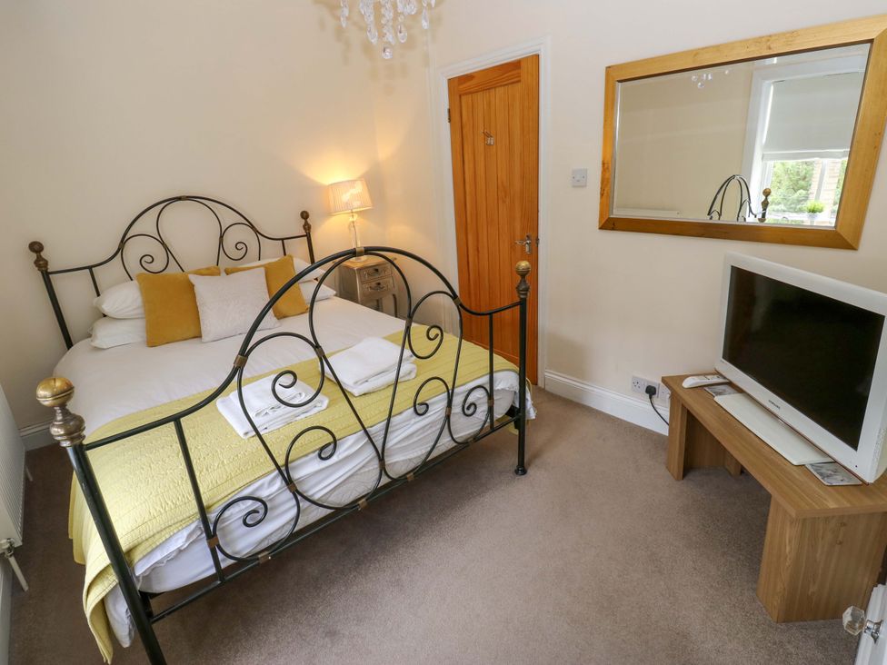 A bedroom with a bed and television at Maria Cottage in Haworth