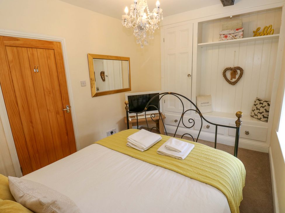 A bedroom with a bed and television at Maria Cottage in Haworth