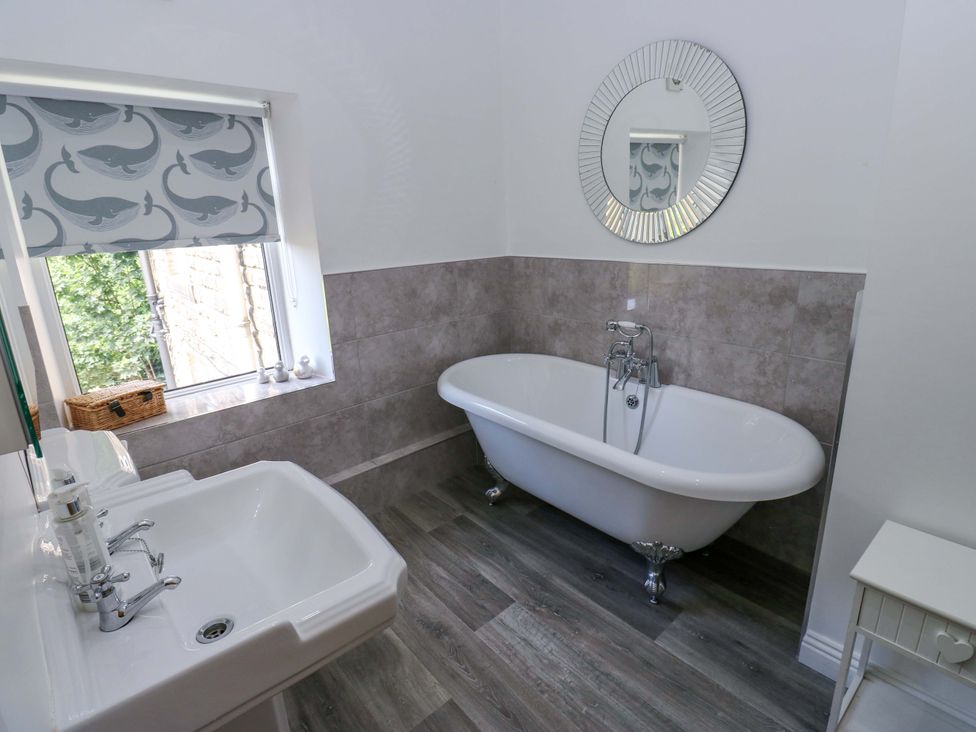 A bathroom with a bathtub and sink at Maria Cottage in Haworth