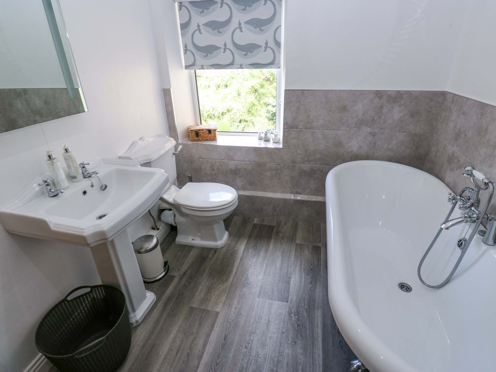 A bathroom with a sink, toilet, and bath tub at Maria Cottage in Haworth