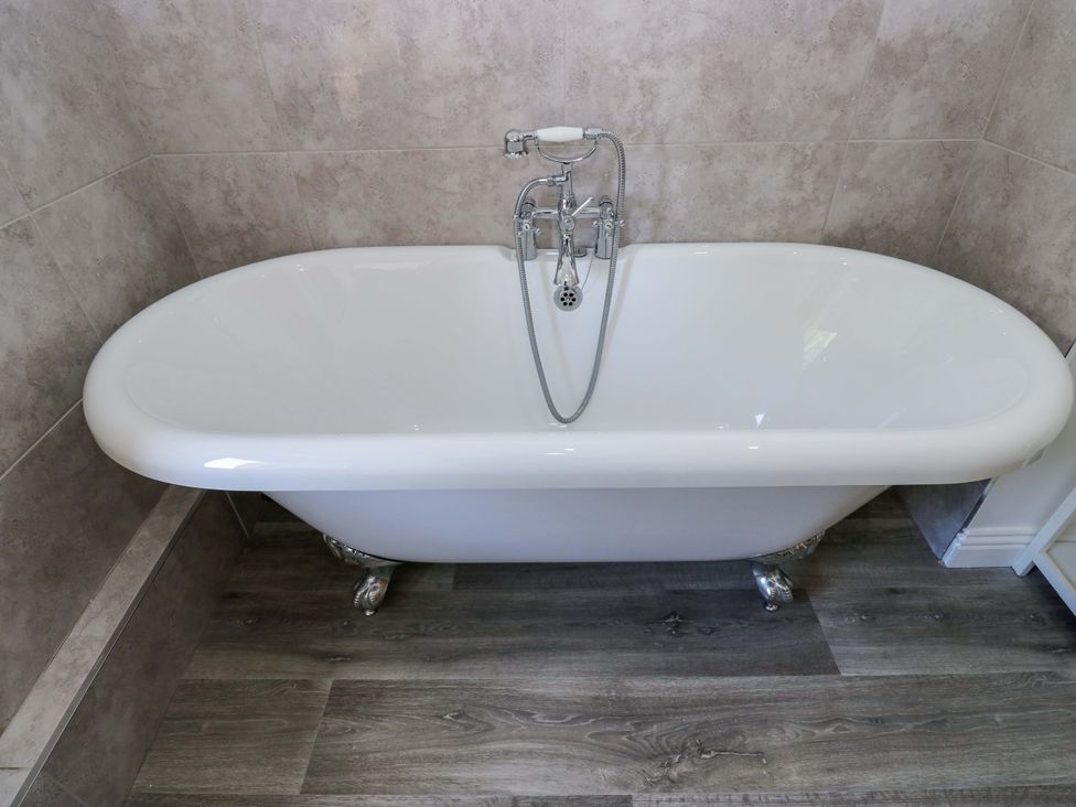 A bathtub with a faucet in a bathroom at Maria Cottage in Haworth