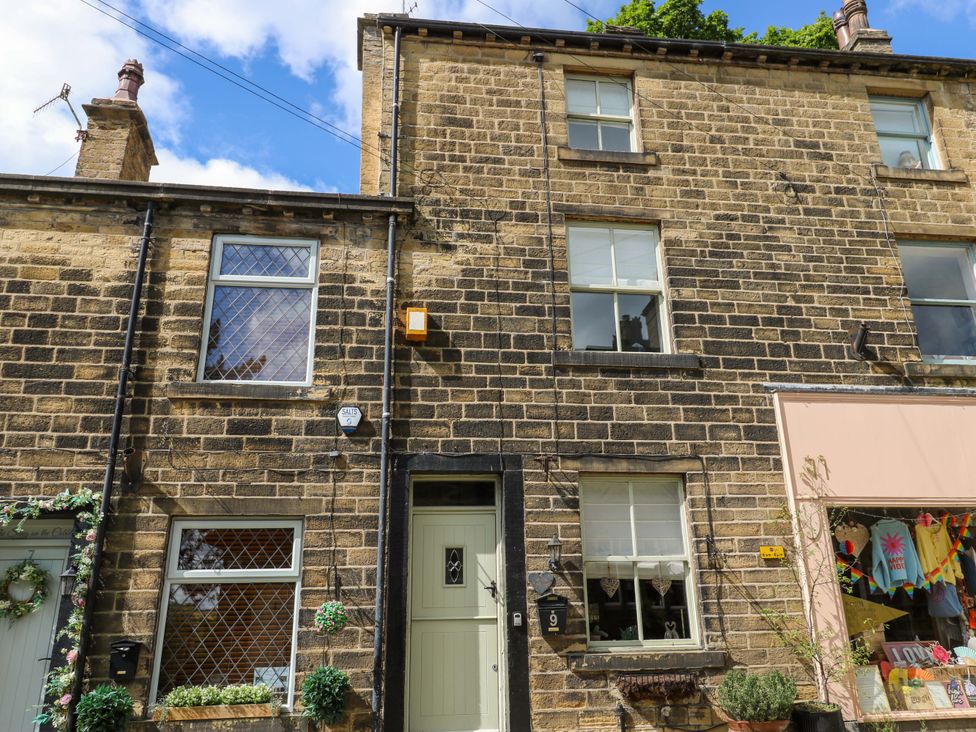 A building exterior with windows and shopfront at Maria Cottage in Haworth
