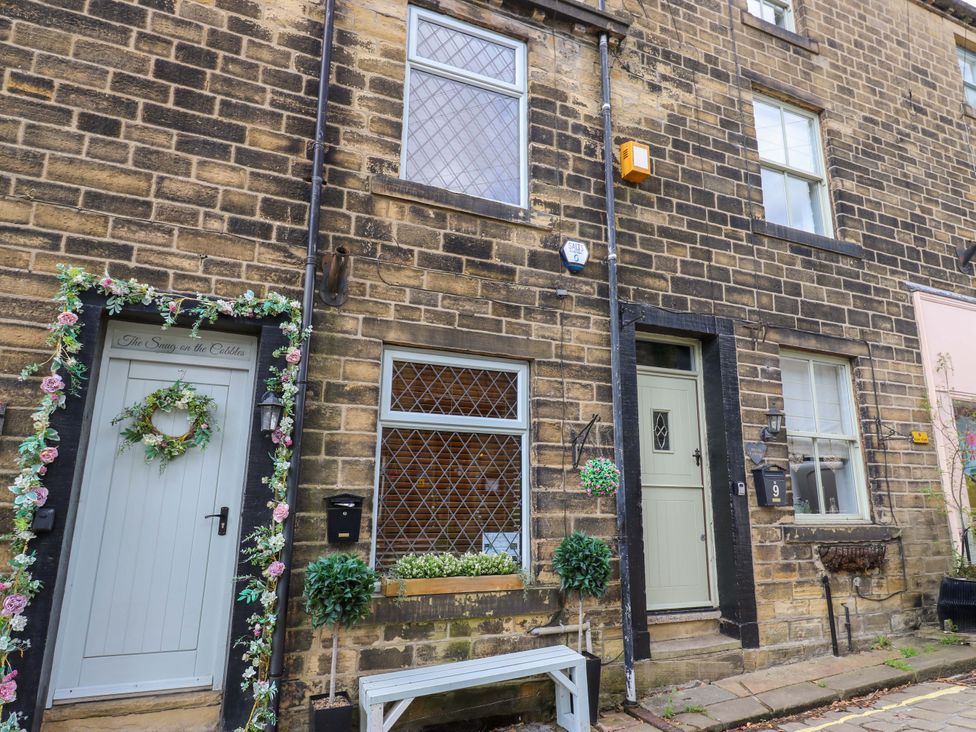 A house exterior with two doors and a window at Maria Cottage in Haworth