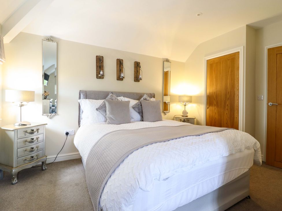 A bedroom with a bed and bedside table at Moelfre Cottage in Llanbedr