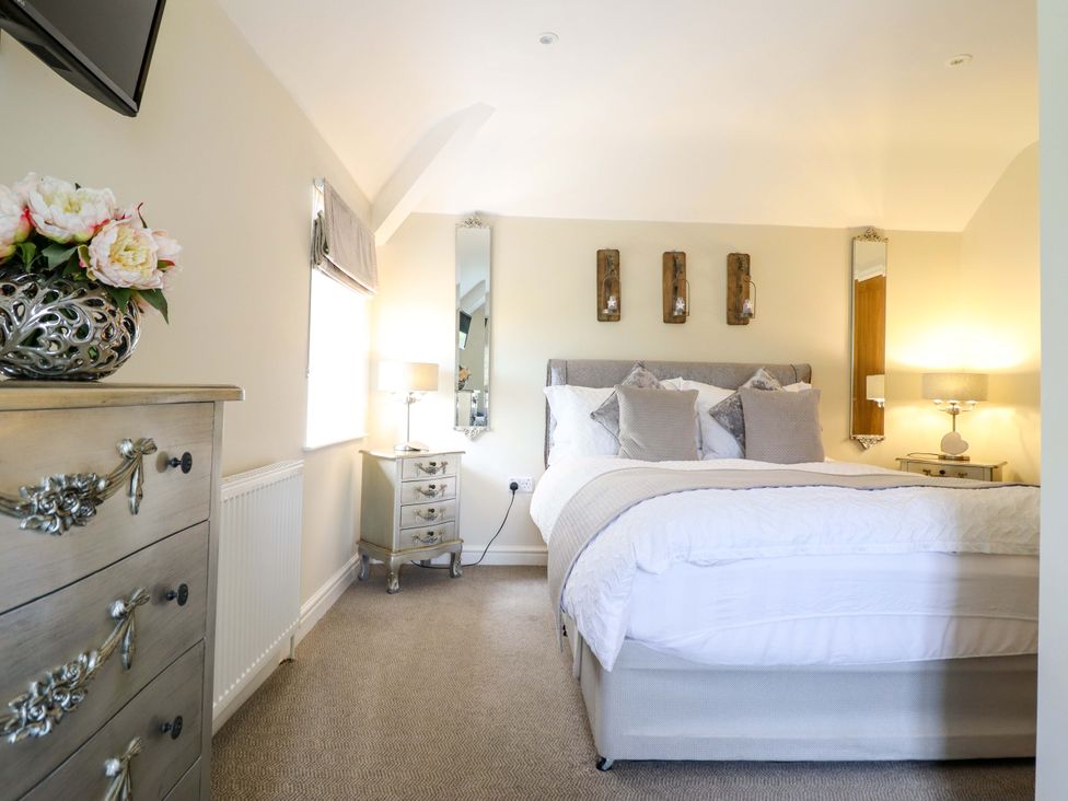 A bedroom with a bed and a nightstand at Moelfre Cottage Llanbedr