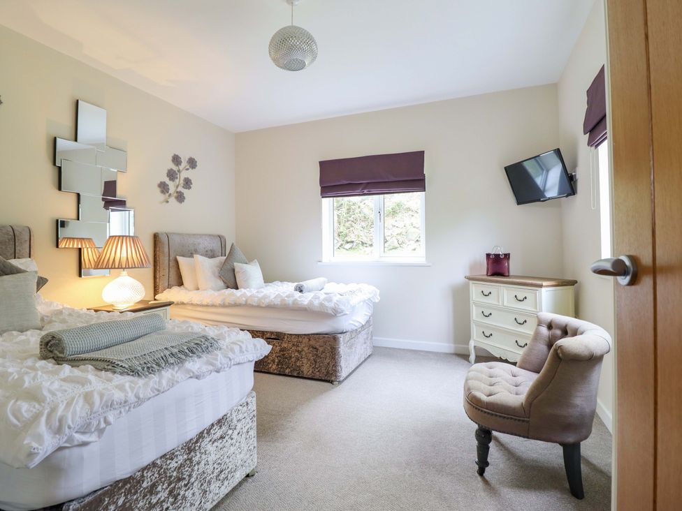 A bedroom with two beds and a window at Moelfre Cottage Llanbedr
