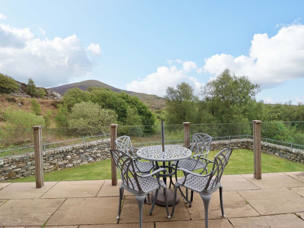 An outdoor seating area with table and chairs at Moelfre Cottage in Llanbedr