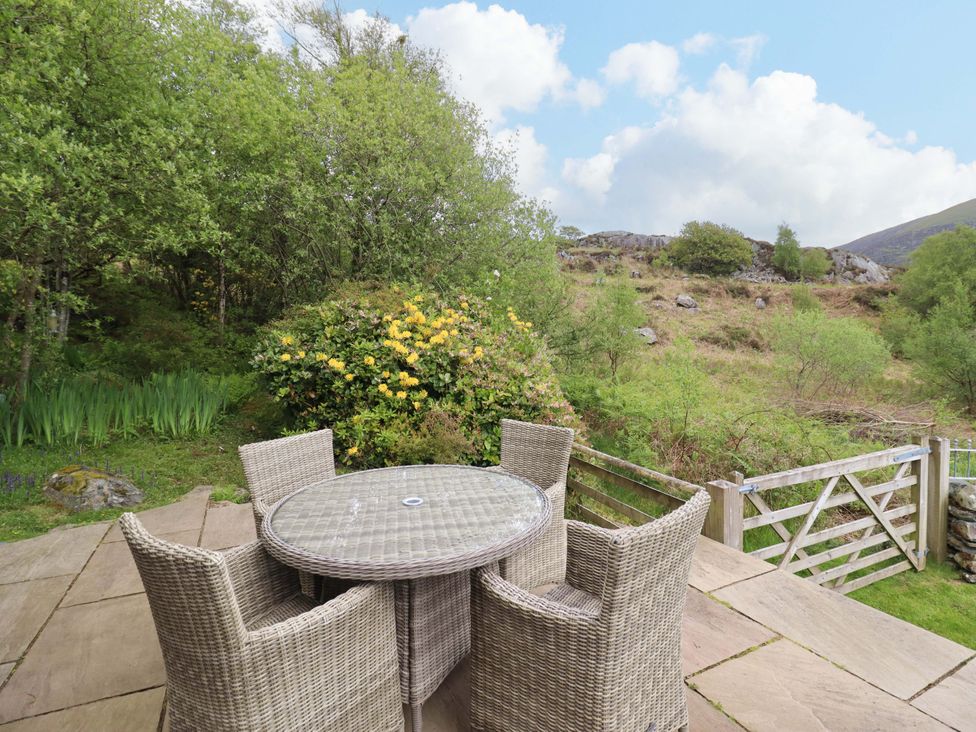 A garden with a table and chairs at Moelfre Cottage Llanbedr
