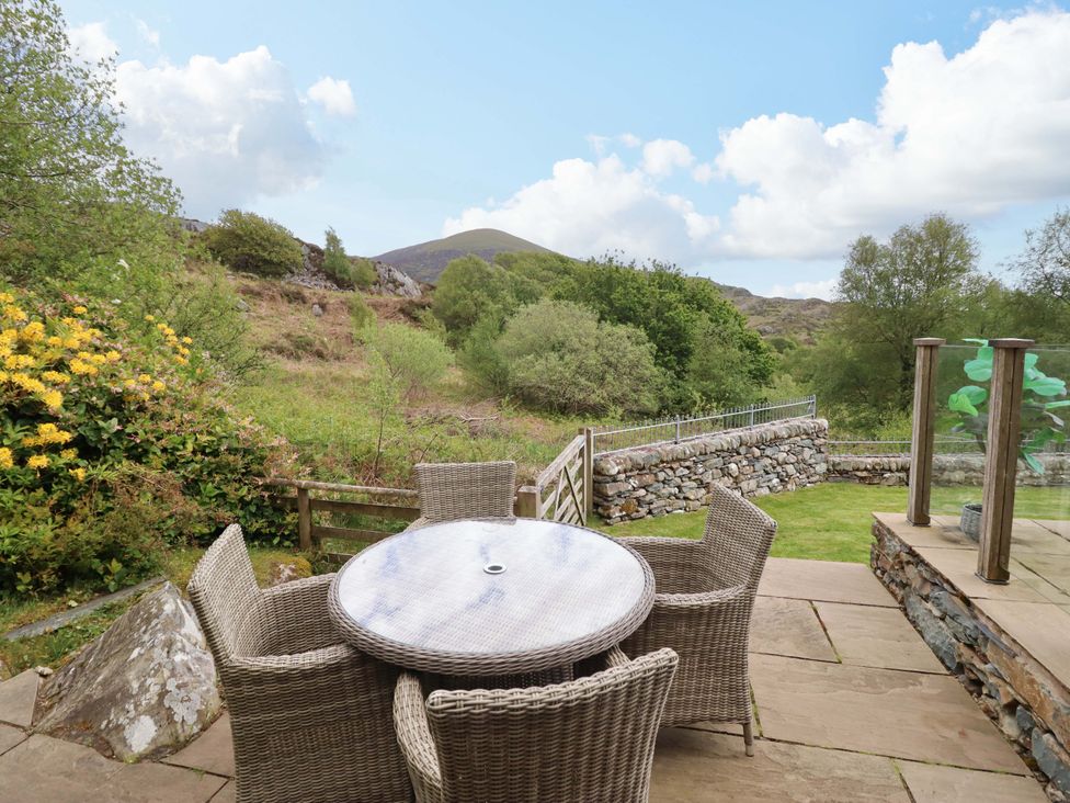 An outdoor area with a table and chairs at Moelfre Cottage in Llanbedr