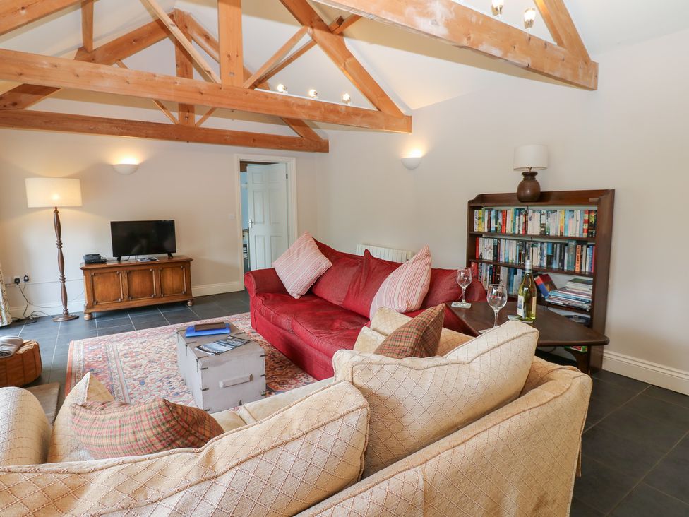 A living room with a sofa, TV, and bookshelf at Gallow Law Cottage in Bellingham