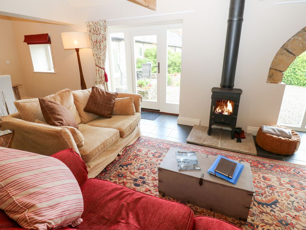 A living room with a wood stove and seating area at Gallow Law Cottage Bellingham