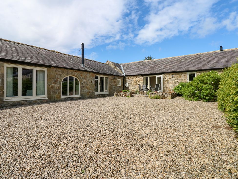 An outdoor area with a gravel surface and seating at Gallow Law Cottage Bellingham