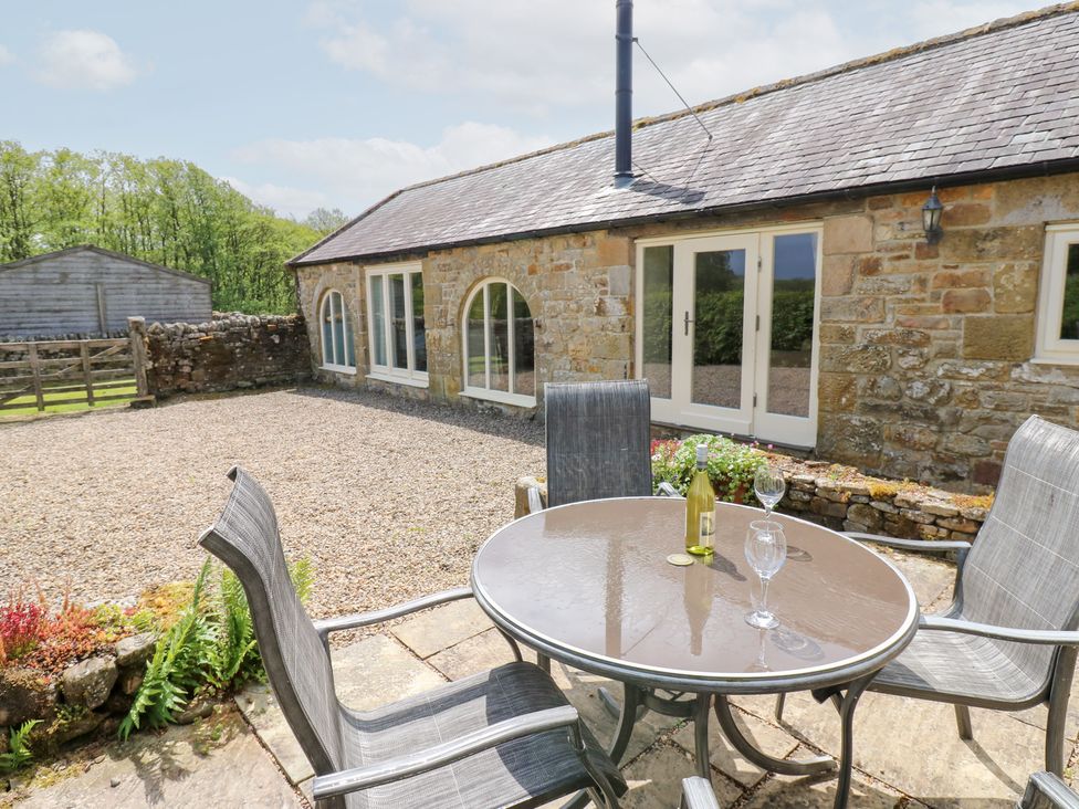 An outdoor seating area with a table and chairs at Gallow Law Cottage Bellingham