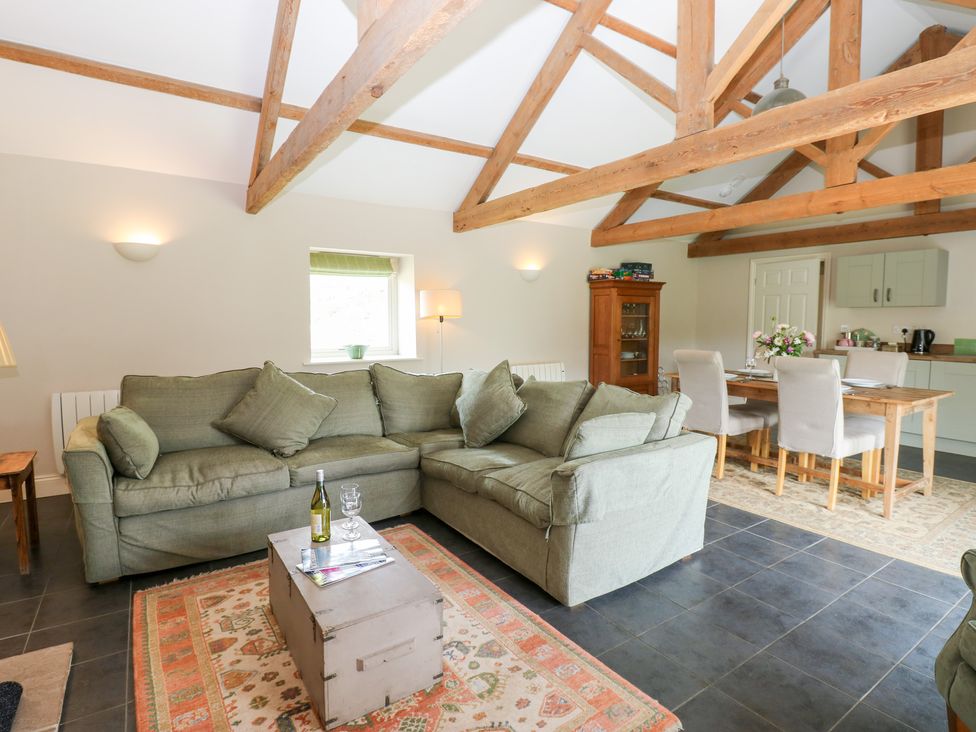 A living room with a sofa, table, and chairs at Shepherds Burn Cottage in Bellingham