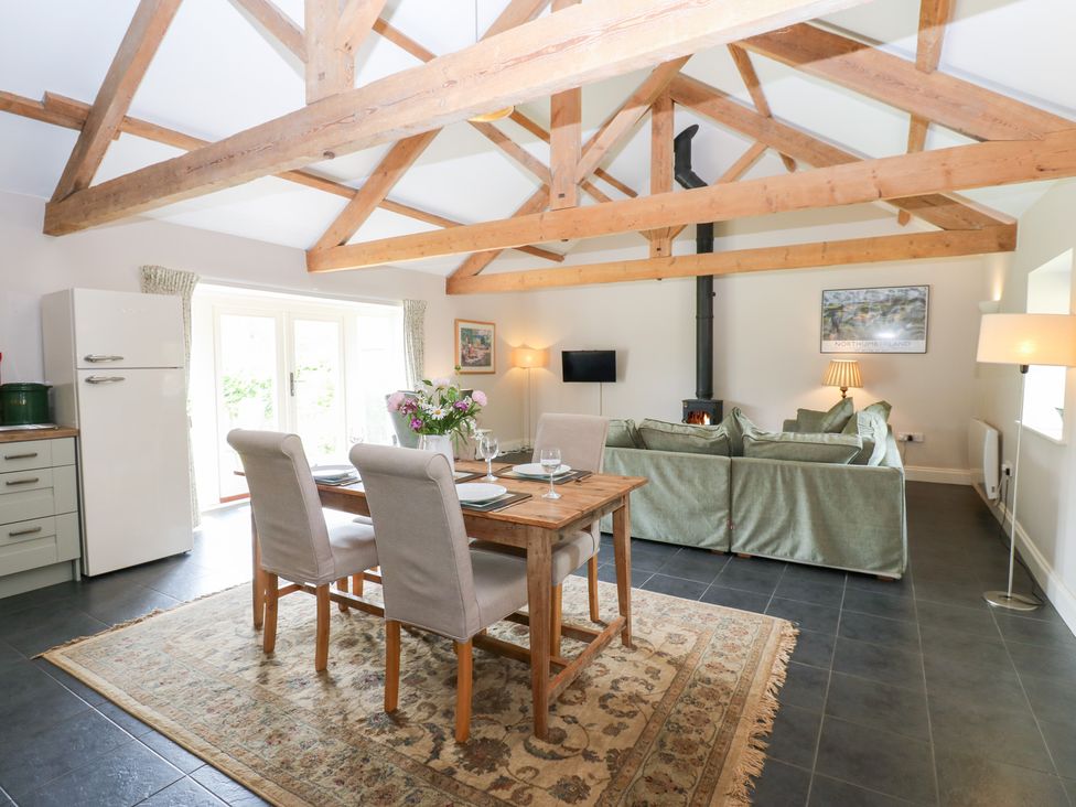 A dining room with a table and chairs at Shepherds Burn Cottage in Bellingham