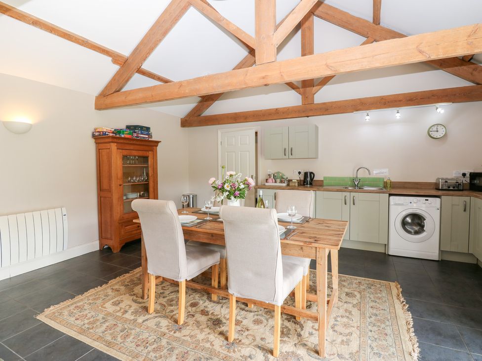 A kitchen with a dining table and chairs at Shepherds Burn Cottage in Bellingham