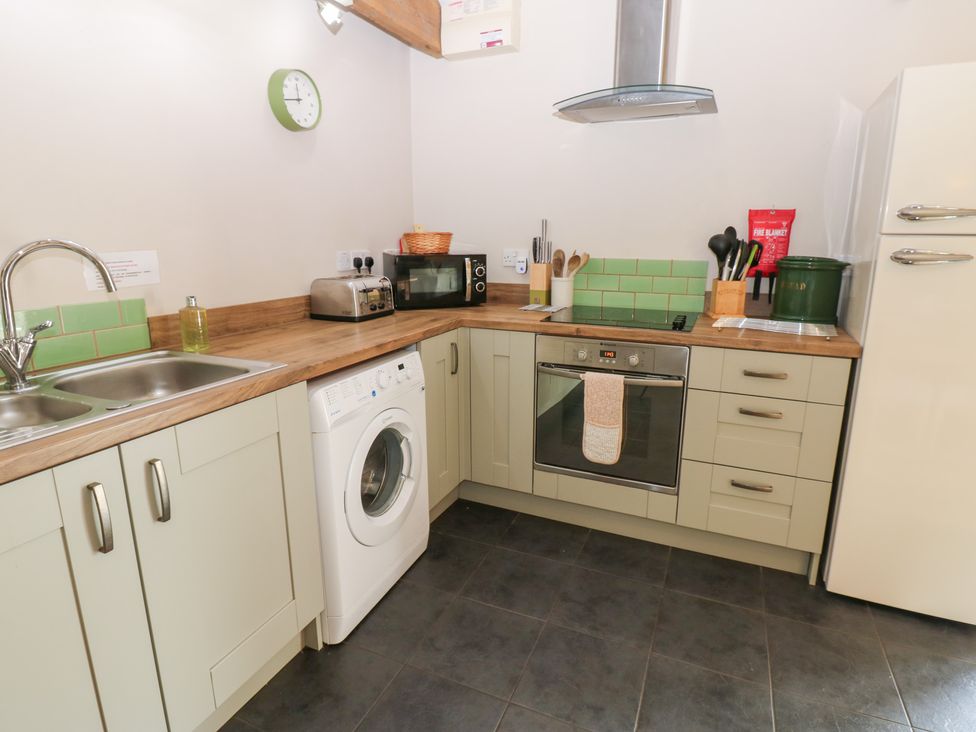 A kitchen with appliances and cabinets at Shepherds Burn Cottage in Bellingham