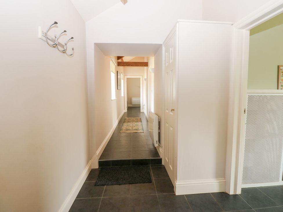 A hallway with coat hooks and a door at Shepherds Burn Cottage in Bellingham