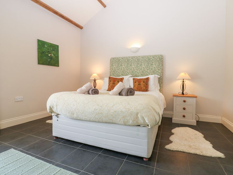 A bedroom with a bed and bedside table at Shepherds Burn Cottage in Bellingham