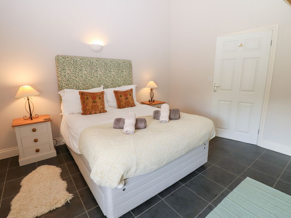 A bedroom with a bed and bedside table at Shepherds Burn Cottage in Bellingham