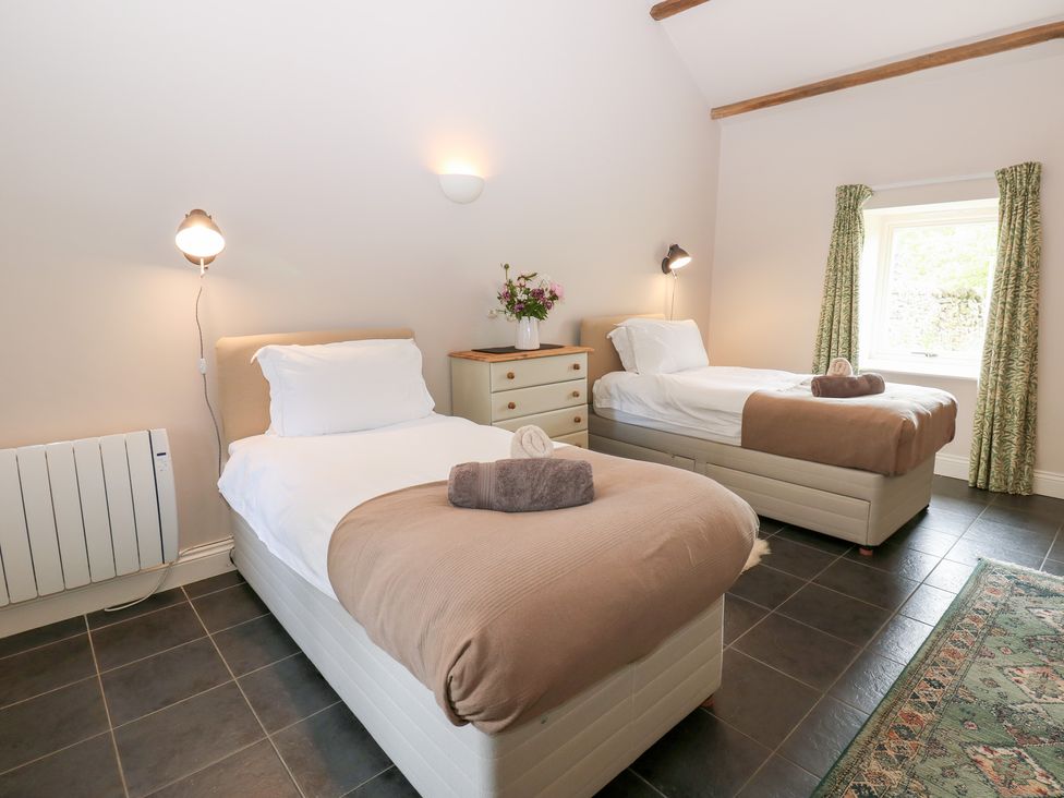 A bedroom with two beds and a dresser at Shepherds Burn Cottage in Bellingham