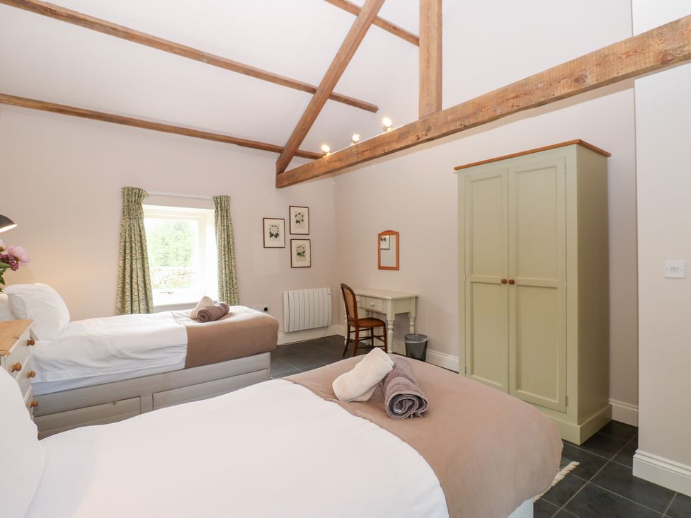 A bedroom with two beds and a desk at Shepherds Burn Cottage Bellingham