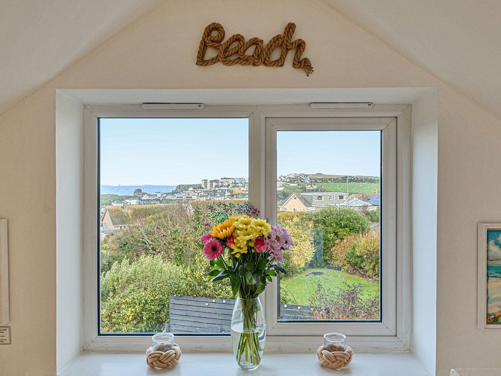 A window with flowers in a vase at Sunset View in Porth
