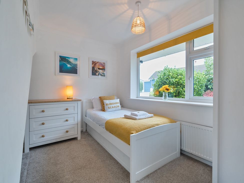 A bedroom with a single bed and a dresser at Sunset View in Porth