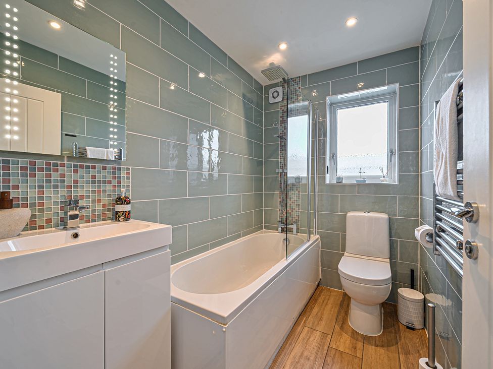 A bathroom with a tub, sink, and toilet at Sunset View in Porth